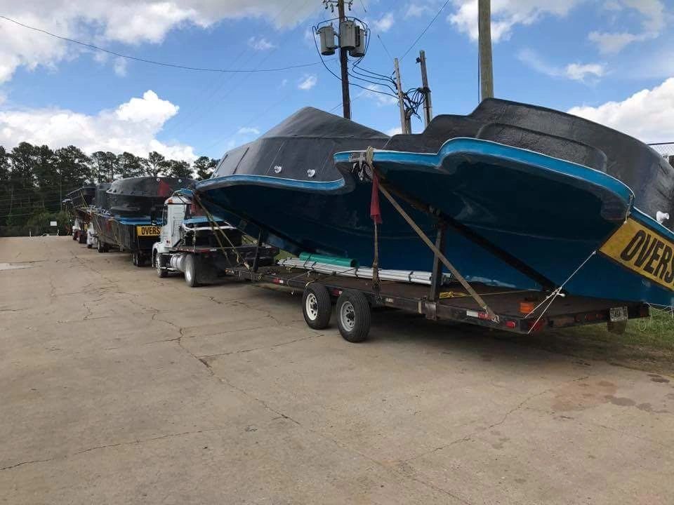 Oversize load trailer truck transporting fiberglass pool shells