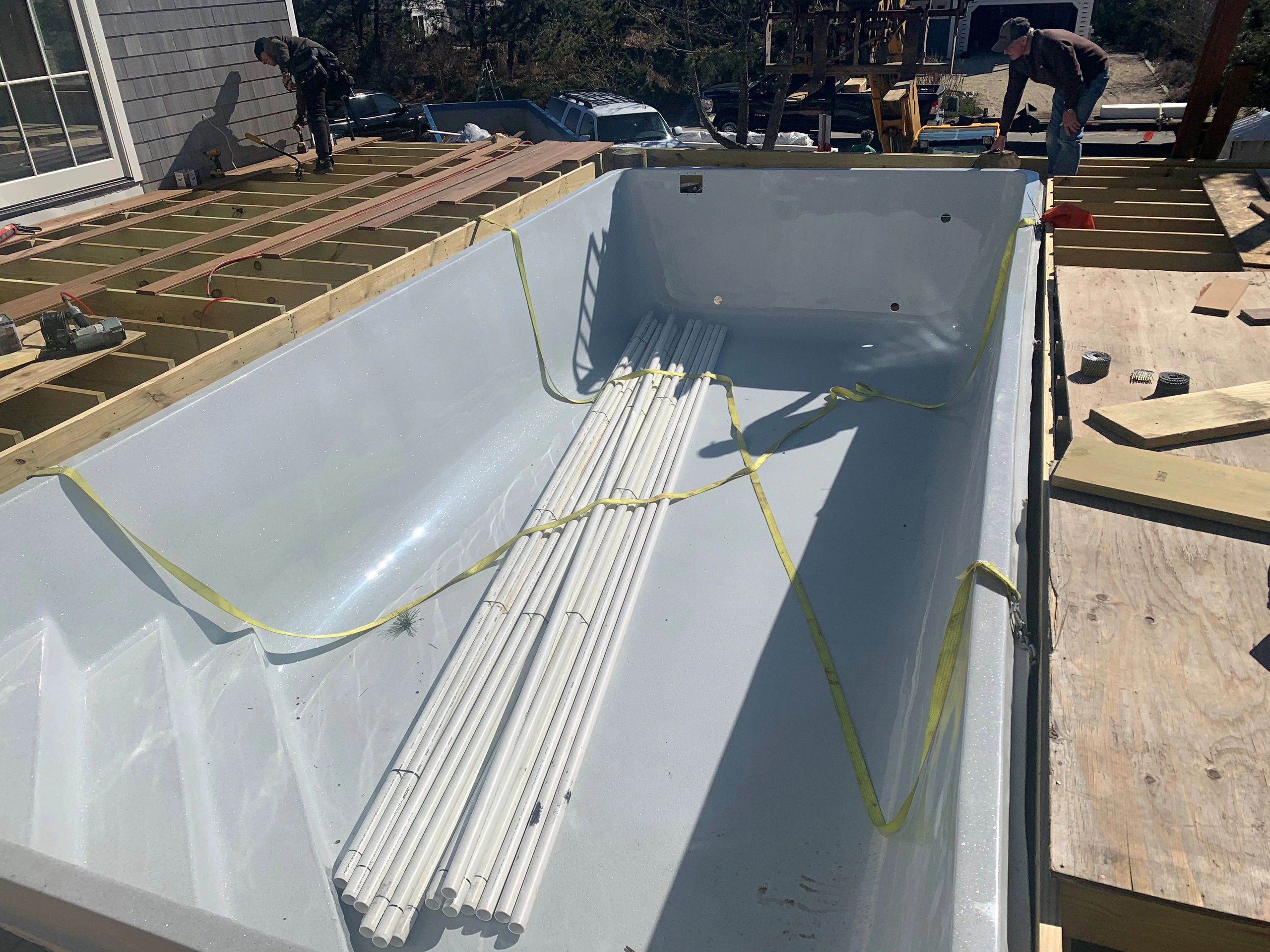 Oversize load truck transporting a large fiberglass pool on the highway