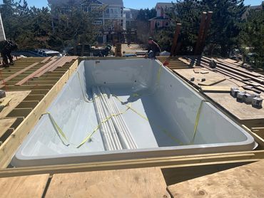 Overhead view of in-ground pool under construction with deck framing